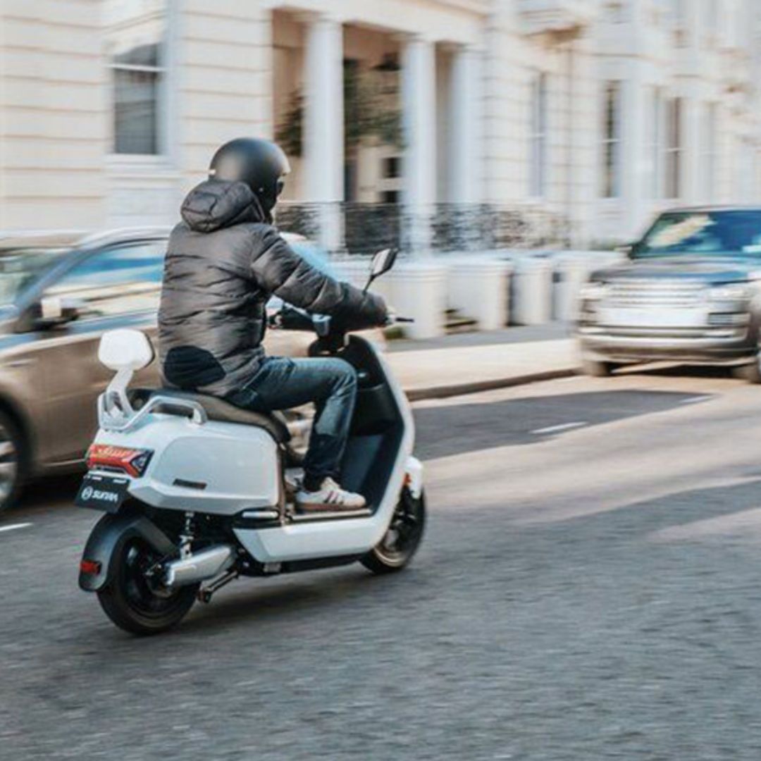 a person riding a scooter down a busy road