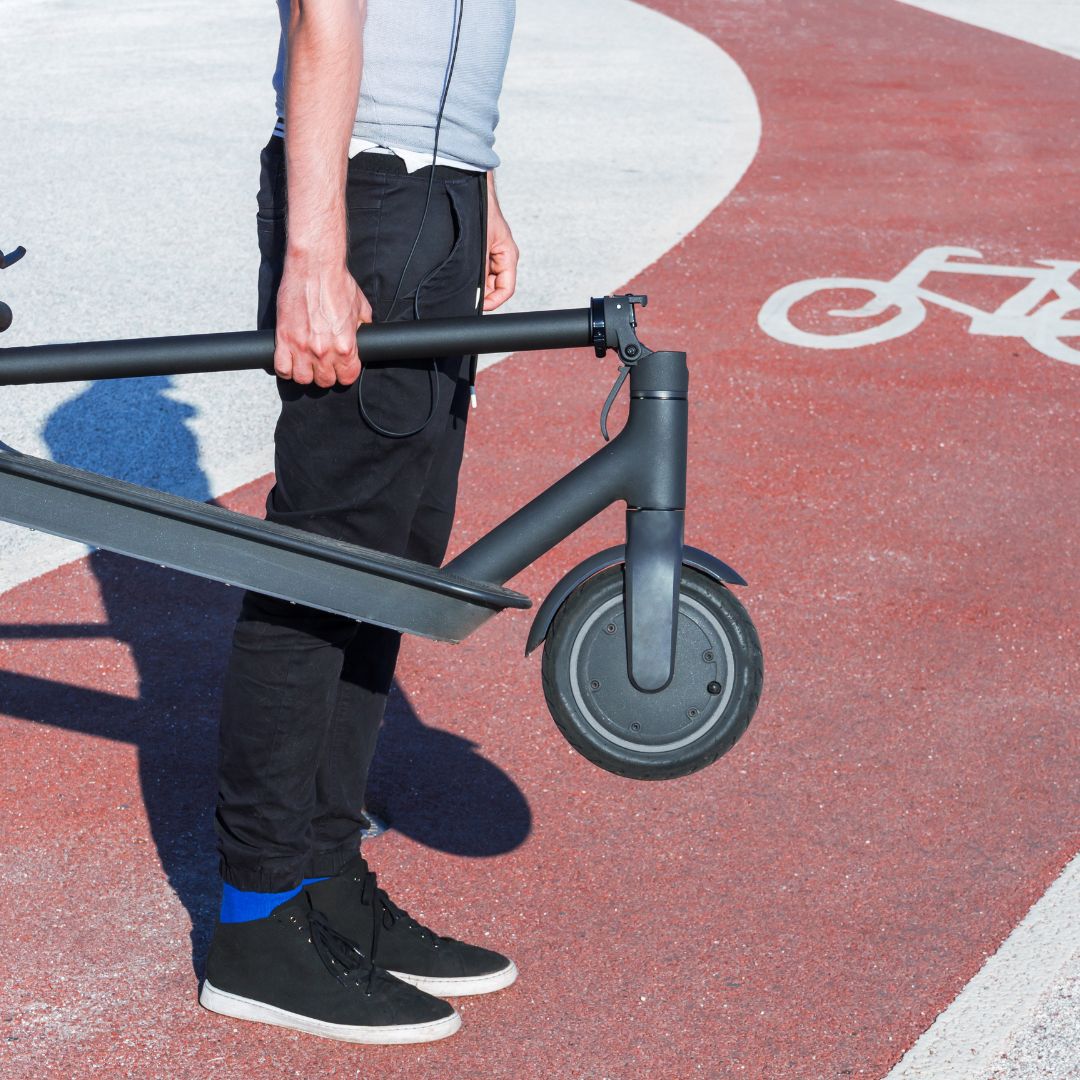 Folded electric scooter being held