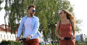two people riding scooters smiling and having fun