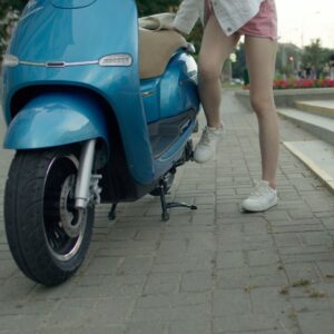 Person leaning on an electric scooter.